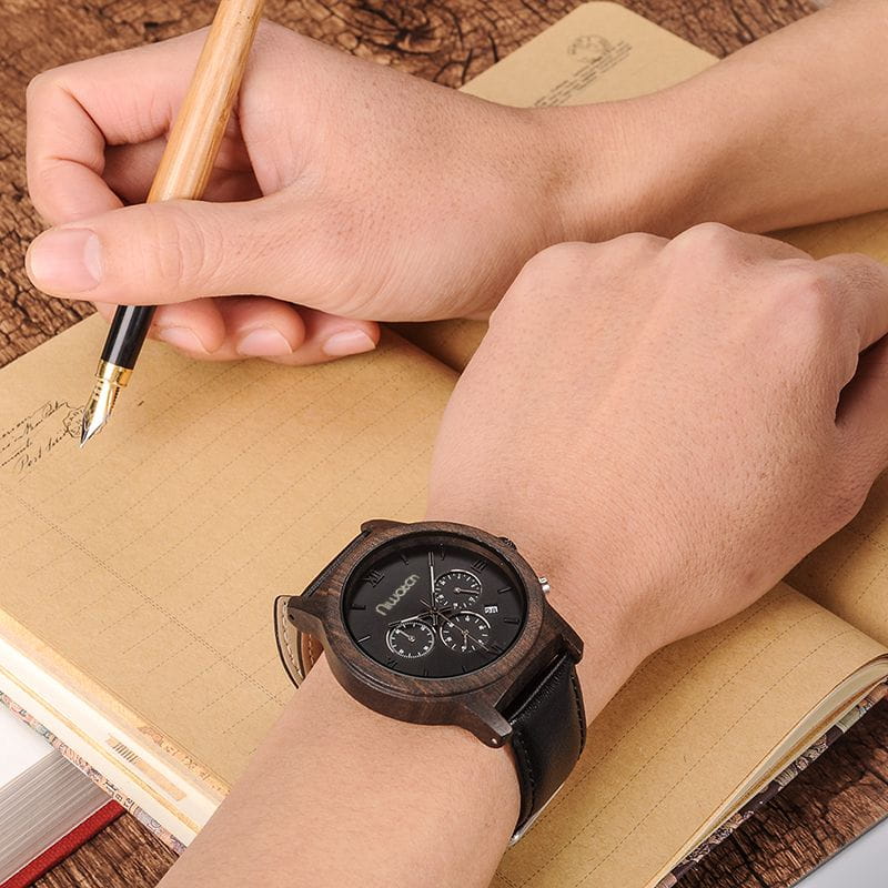 drewniany-zegarek-niwatch-chrono-heban-na-pasku-na-nadgarstku-osoby-piszacej-piorem-w-zeszycie